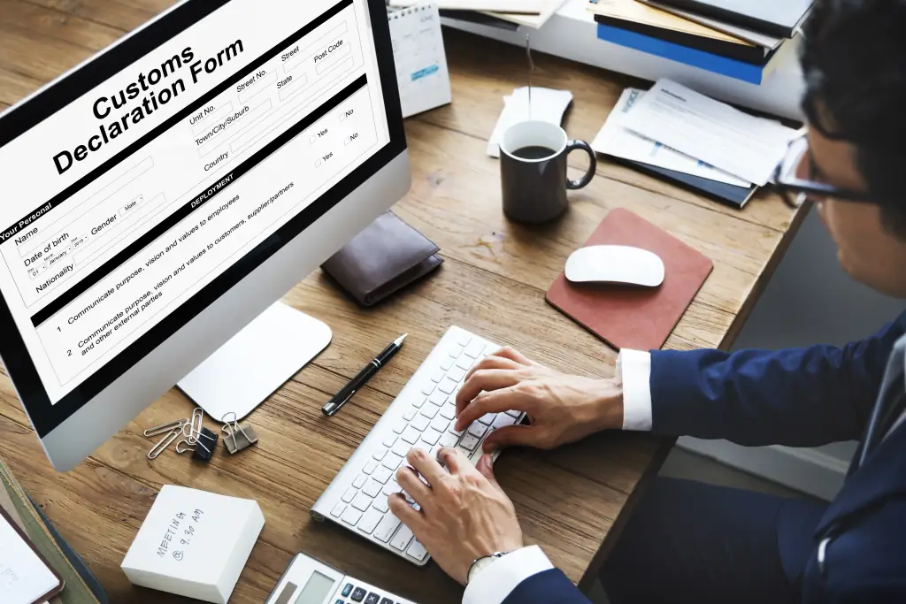 A trader completing a customs declaration form on a desktop computer
